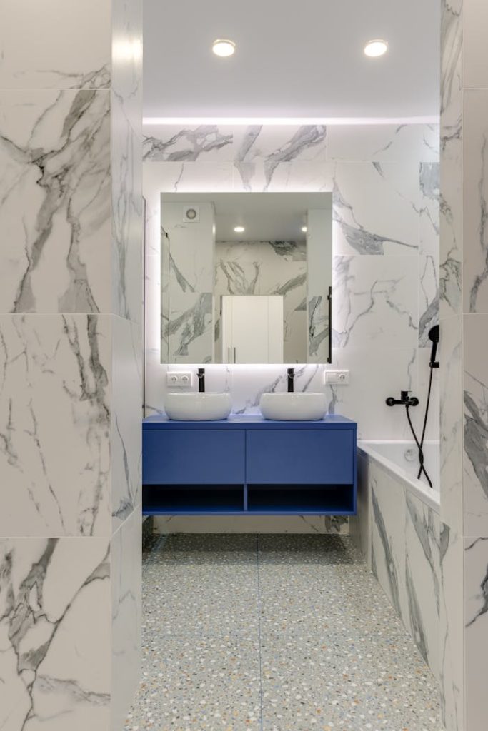 Crafting Captivating Headlines: Your awesome post title goes here Stylish marble bathroom with blue vanity and double sinks.