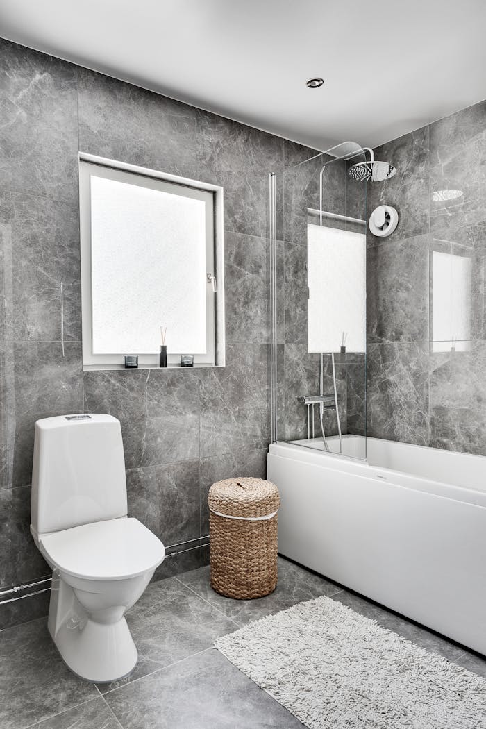 gallery-1 Elegant bathroom interior featuring marble tiles, toilet, and bathtub in modern design.