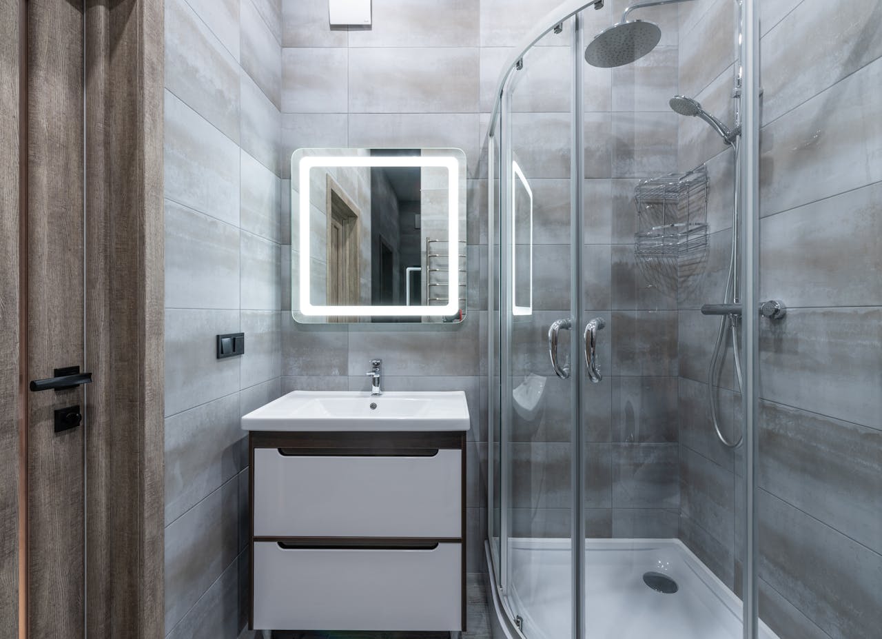 our-services-3 Contemporary washbasin under mirror against shower room with glass walls and tiles at home