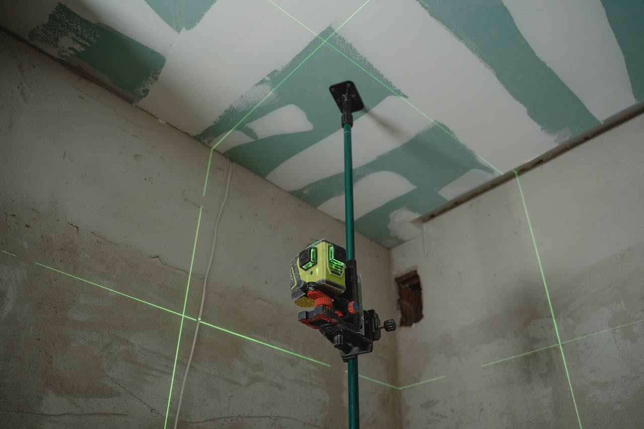 gallery-6 A laser level tool in action at an indoor construction site with marked walls.