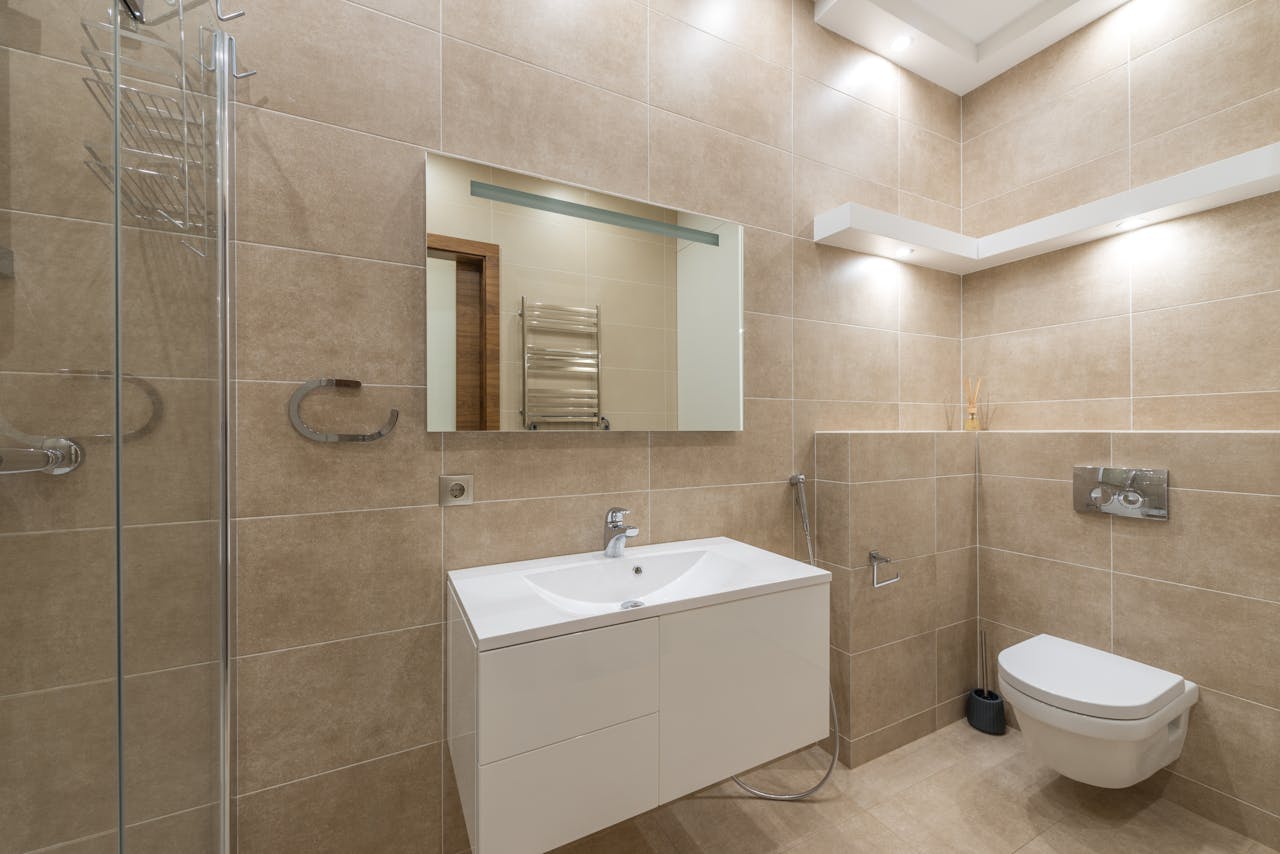 gallery-3 Elegant bathroom with modern fixtures and beige tiles.
